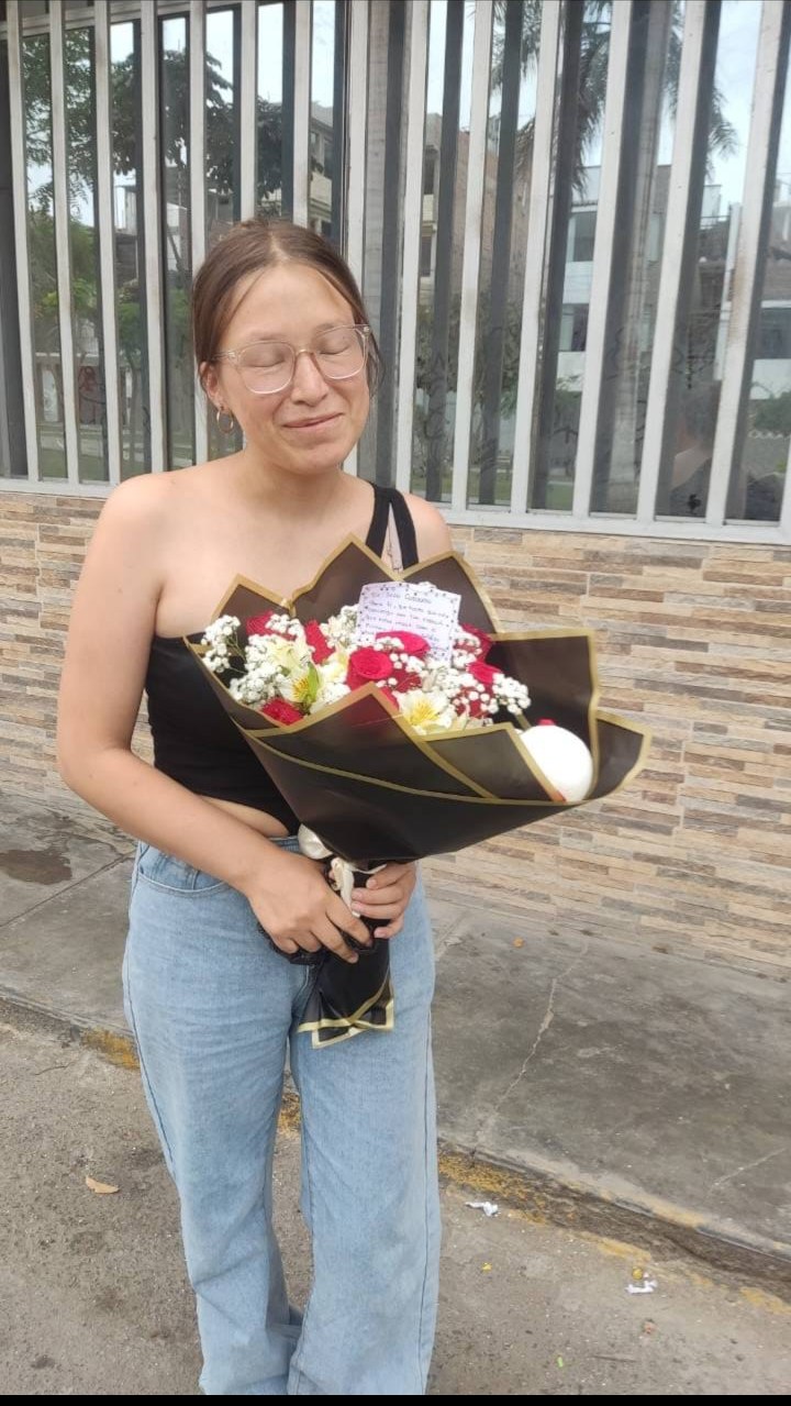 Clienta recibiendo un ramo de rosas de Munay