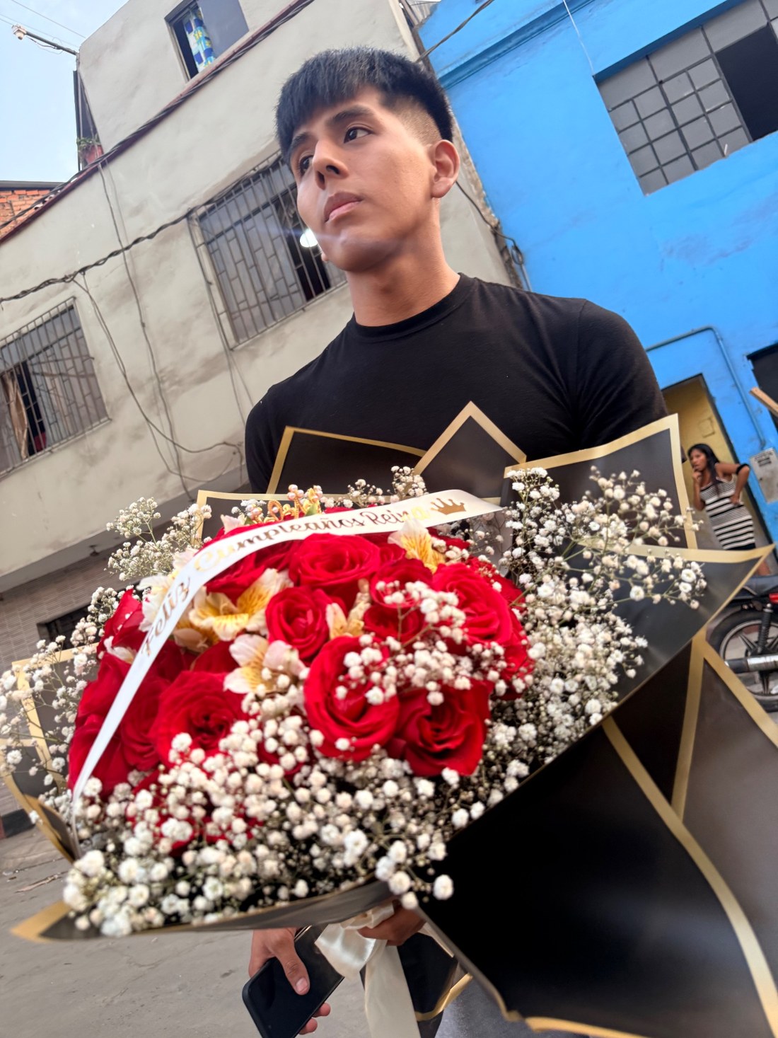 Cliente con un ramo de rosas rojas en envoltorio negro y dorado